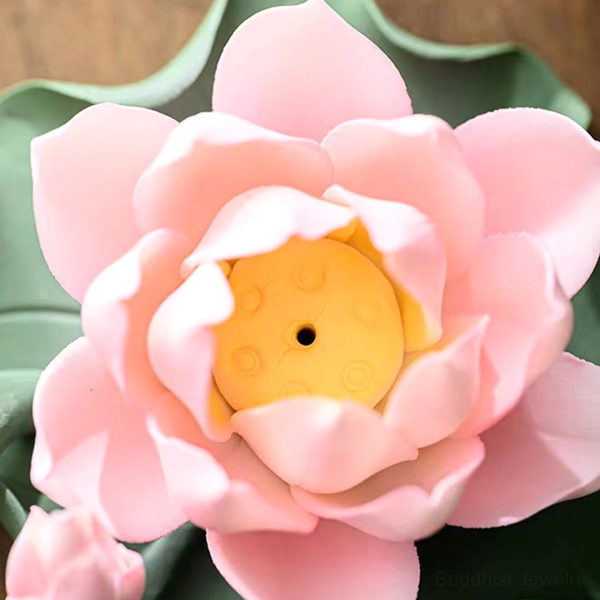Extreme close-up of lotus incense burner showing incense insertion hole and pink lotus petals detail