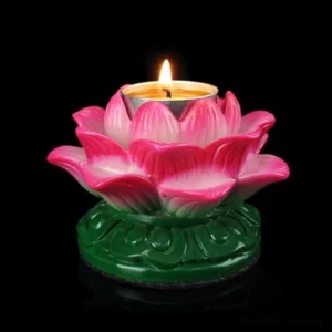 Single lotus ceramic candle holder with lit tealight in pink gradient finish, green carved base, front top close-up view on black studio background