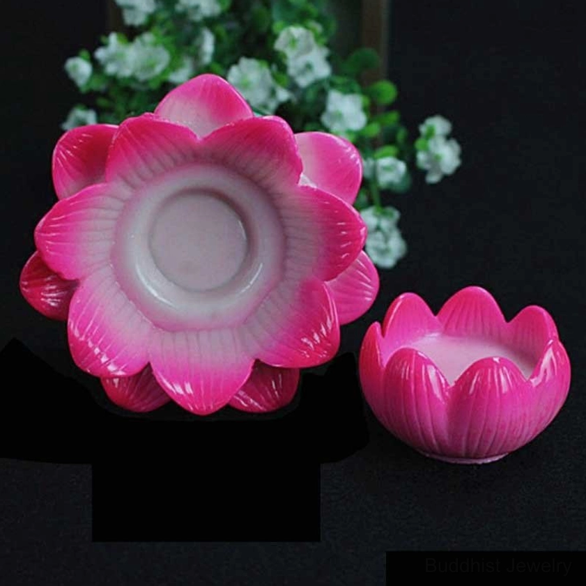 Two small empty lotus candle holders showing side and front angles, one inverted to display interior cup shape, pink gradient ceramic with green bases