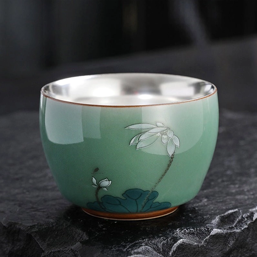 Lotus flower artwork celadon tea cup with silver-lined interior featuring sacred Buddhist enlightenment symbolism