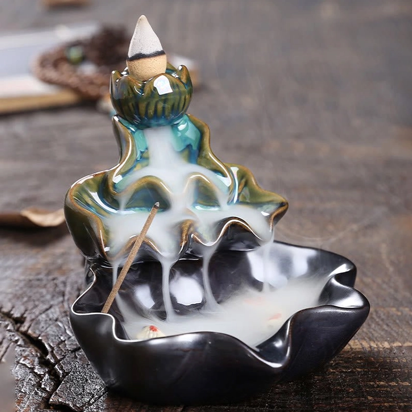 Ceramic backflow incense burner with lotus design and prayer beads on wooden table