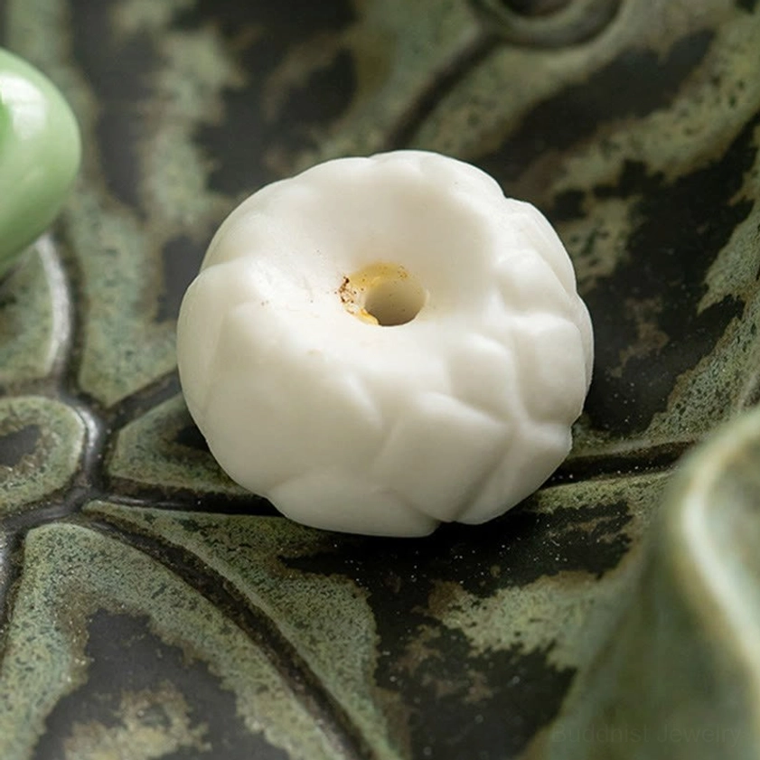 Close-up macro view of lotus-shaped ceramic incense holder on lotus leaf tray with embossed texture detail
