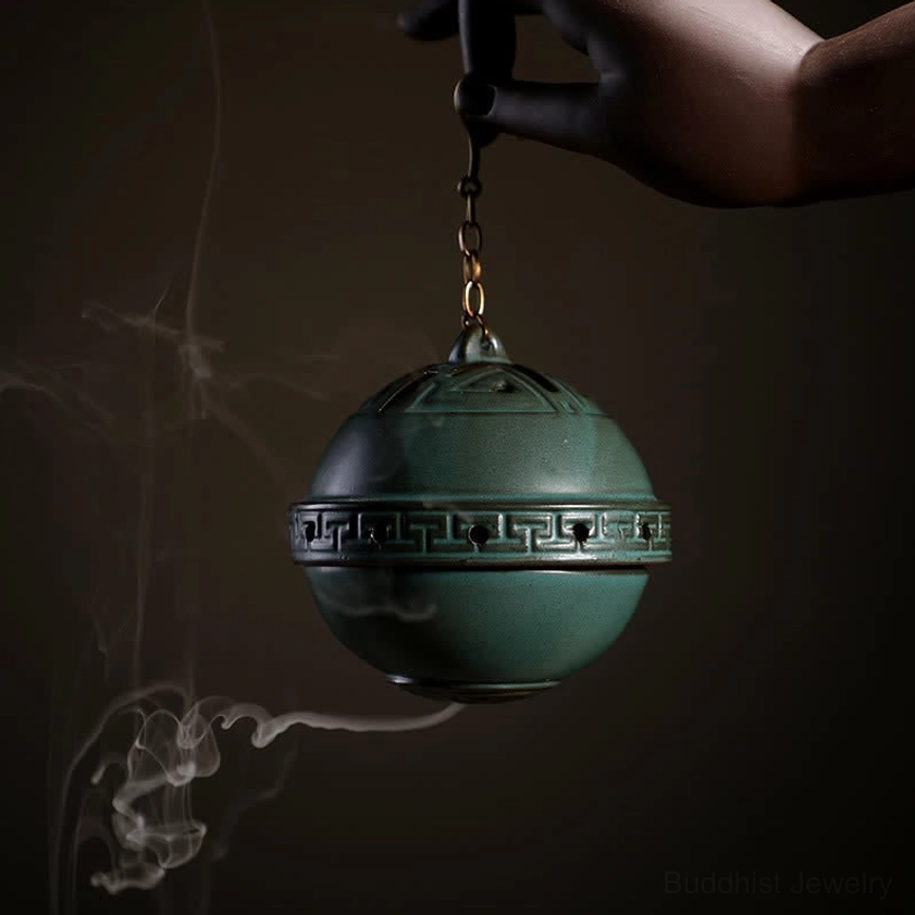 Handmade ceramic lotus incense burner hanging chain close-up with aromatic smoke