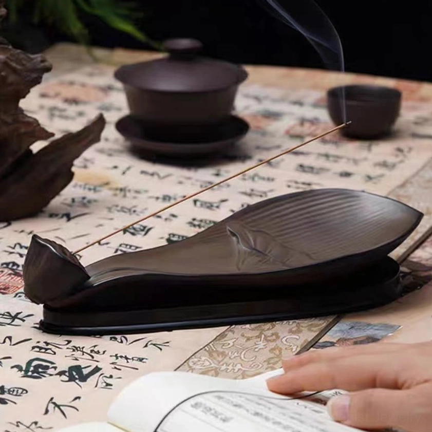 Lotus pod ceramic incense burner with rising incense smoke on vintage calligraphy scroll with full tea service
