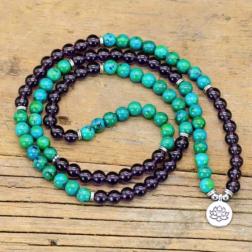 Double-wrap amethyst aventurine lotus bracelet with layered purple and green beads on weathered wood plank