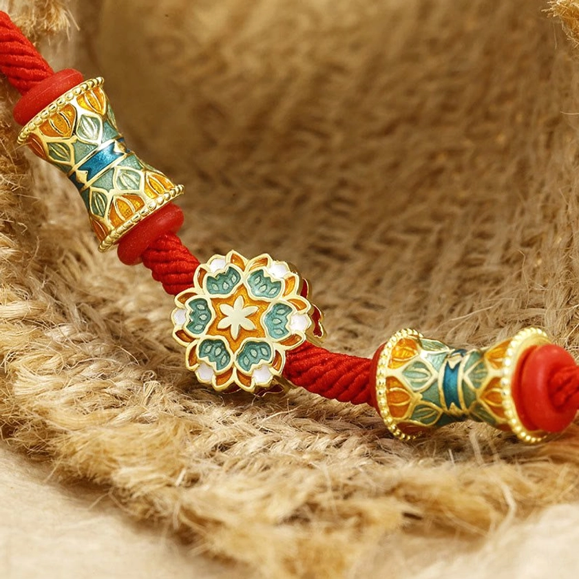 Close-up detail of sterling silver lotus drum bead and red rope with metal fasteners