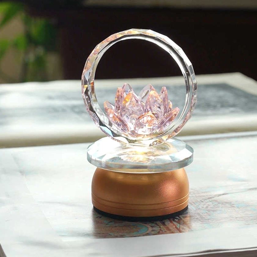 Pink crystal lotus lamp with clear faceted hoop and layered glass copper base on bookshelf