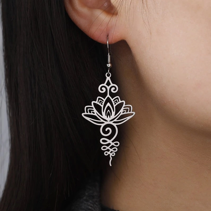 Woman wearing silver lotus drop earrings, Buddhist enlightenment jewelry on ear