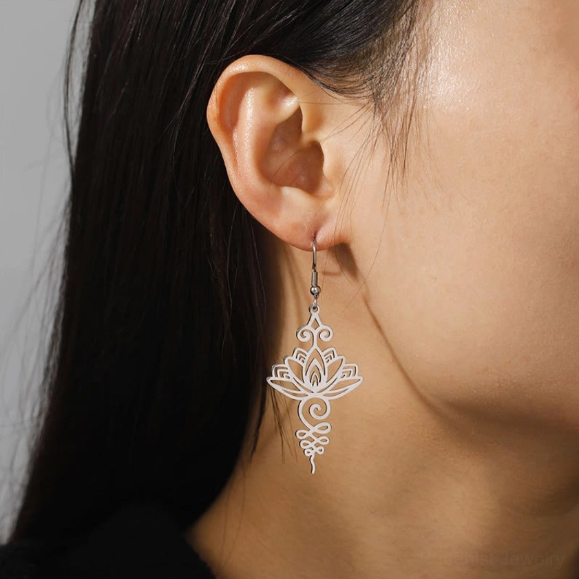 Close-up of woman wearing silver lotus drop earrings, showing delicate filigree detail and comfort fit