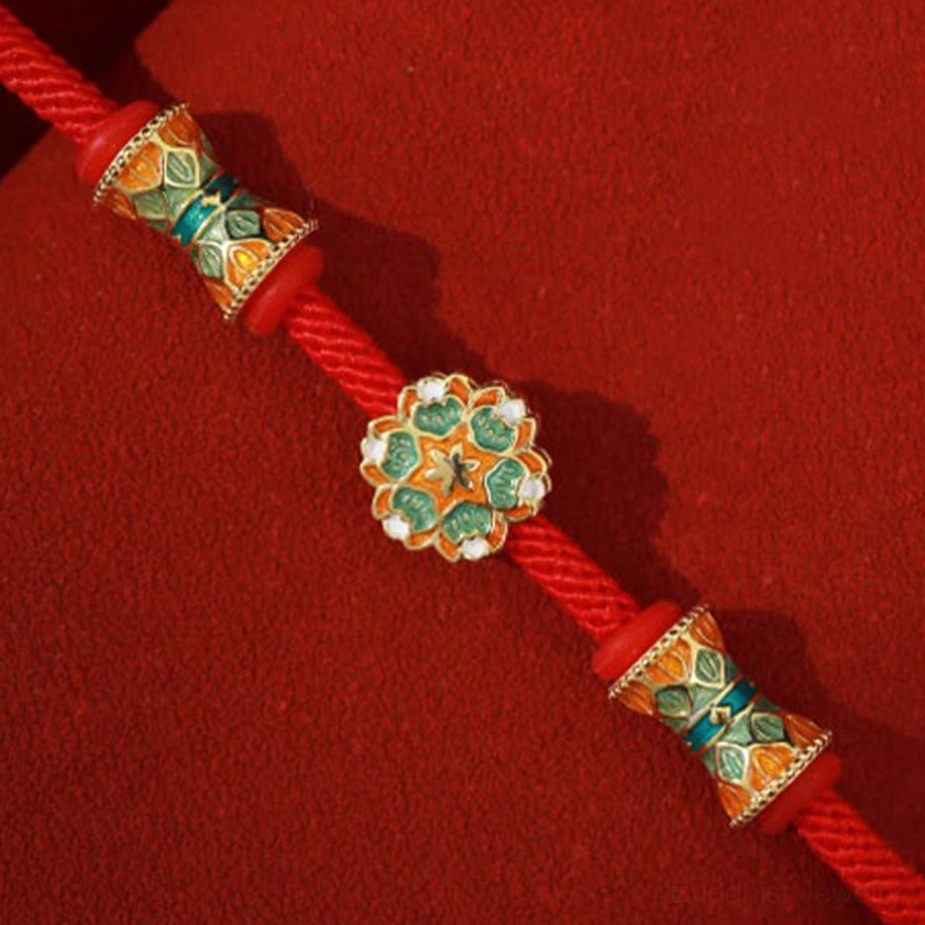Central sterling silver lotus charm with barrel beads on red rope bracelet dark velvet background