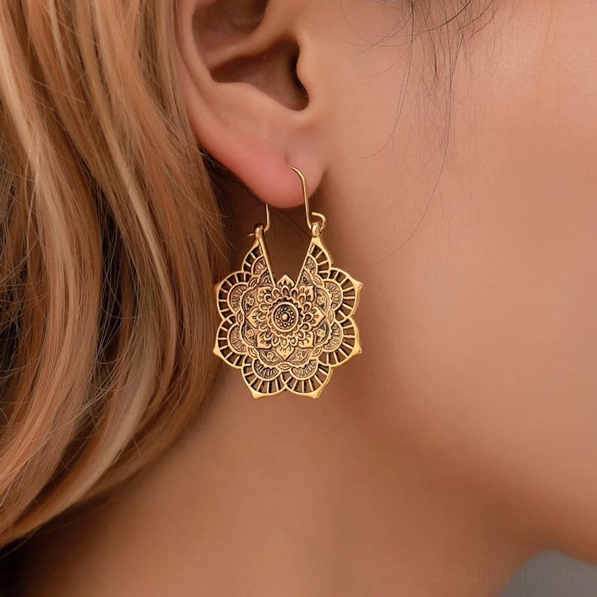 Gold lotus filigree drop earrings on human ear, boho lightweight design with bright antique gold finish
