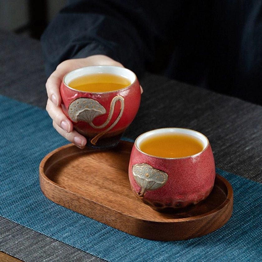 Handcrafted ceramic lotus engraved teacup showcasing natural glaze variations from high-temperature kiln firing