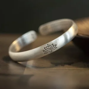 Lotus flower engraved copper cuff bangle bracelet side view showcasing detailed lotus embossment and matte silver finish