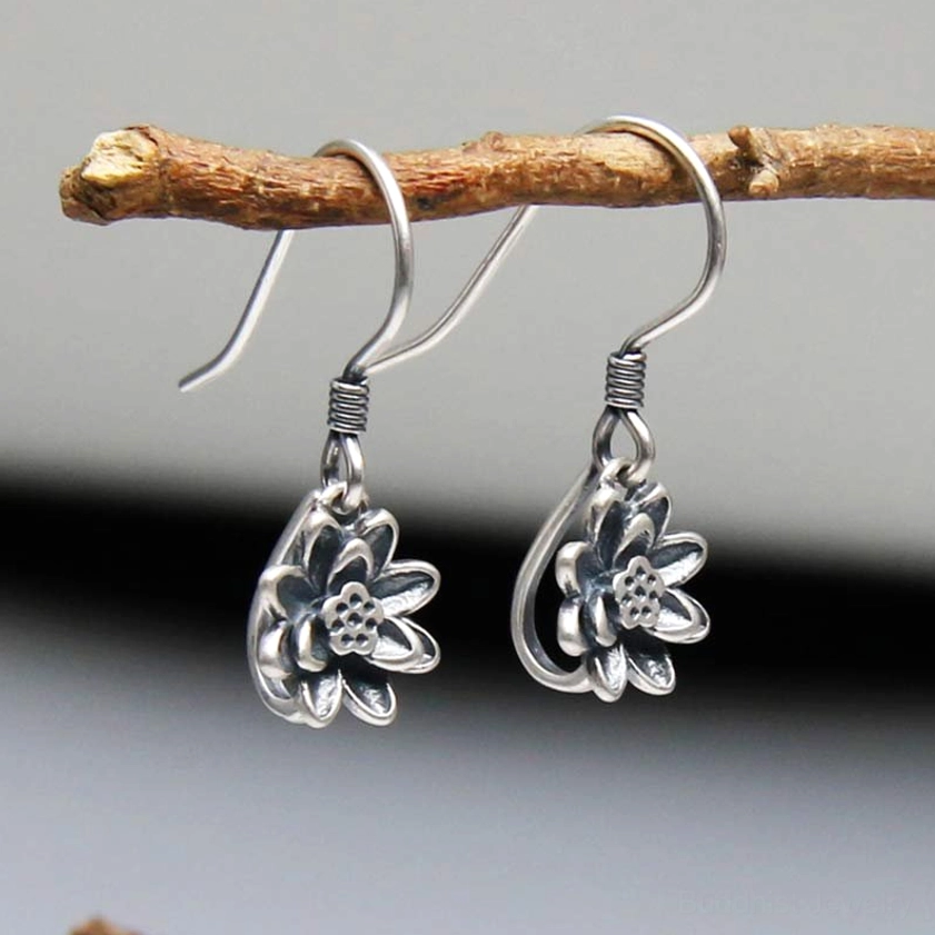 Silver lotus drop earrings with teardrop hook detail and vintage carved lotus pendant, side angle view