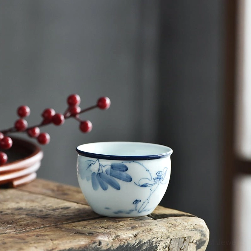 Ceramic teacup with delicate vine and lotus flower pattern, handcrafted blue-and-white porcelain