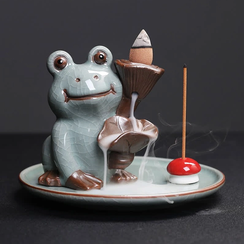 Lotus frog ceramic backflow incense burner with visible flowing incense smoke, left-side view showing lotus leaf shaped smoke channel design