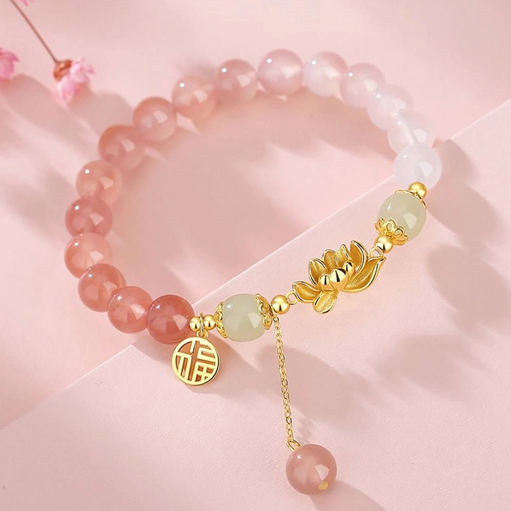 Buddhist lotus Fu character beaded bracelet with mixed color stone beads and gold metal accents on pink background