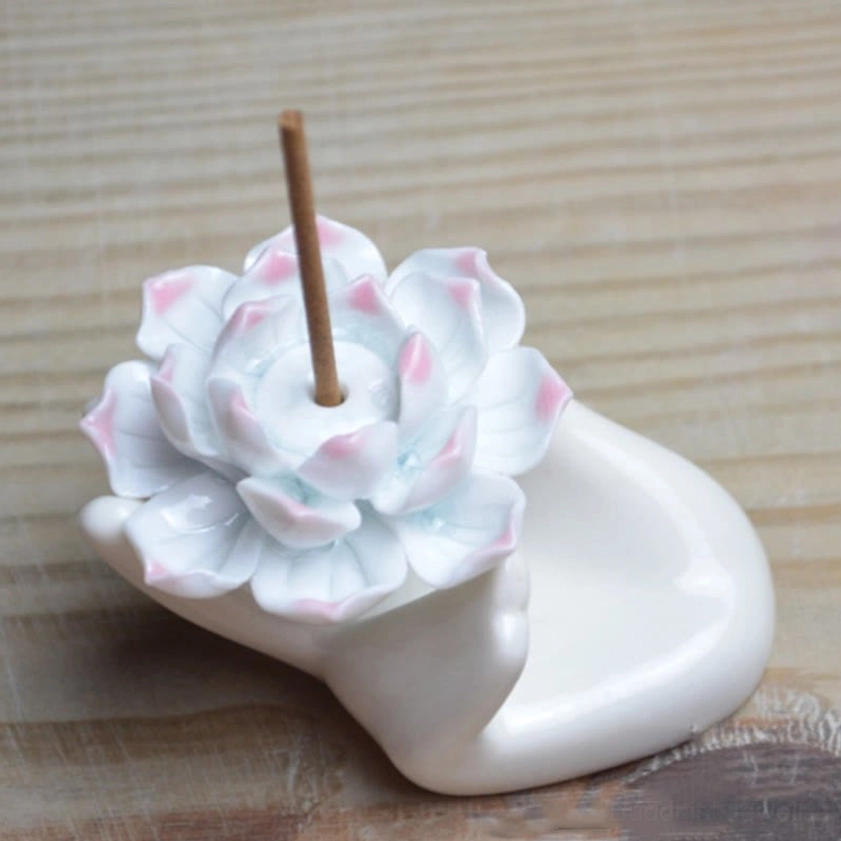 Low angle three-quarter view of detailed ceramic lotus incense burner with large pink-tipped lotus bloom and white hand base