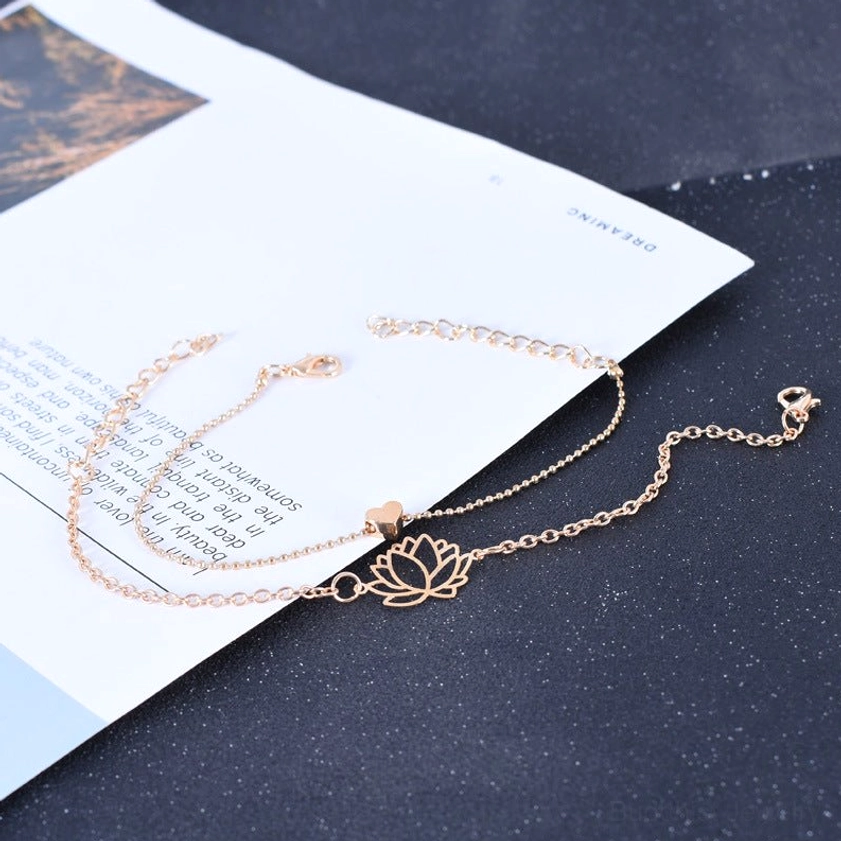 Two lotus heart bracelets with adjustable extension chain displayed on dark background with printed card