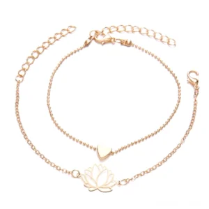 Lotus heart bracelet set flat lay showing rose gold hollow lotus charm and solid heart charm on delicate chains