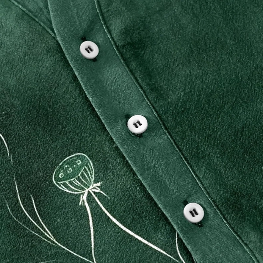 Half-button placket close-up detail - white round buttons on dark green cotton with lotus seedpod water-based print