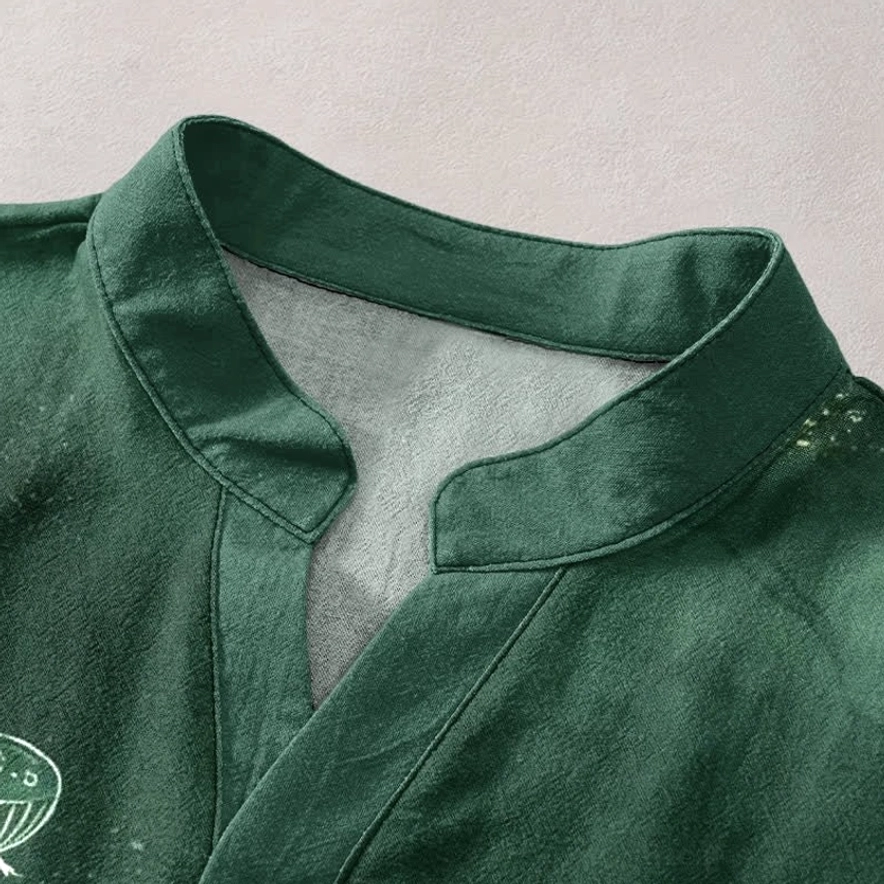 Close-up detail of stand Henley collar on lotus print shirt - dark green woven organic cotton with delicate lotus motif