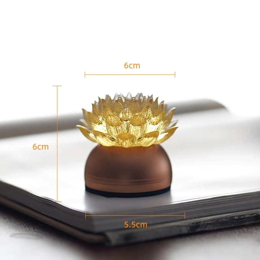 Illuminated lotus liuli glass sculpture placed on notebook, size comparison marks visible, bronze base
