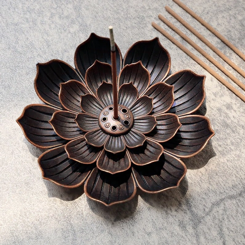 Lotus incense burner overhead view with aged bronze finish and layered petal design on grey stone surface