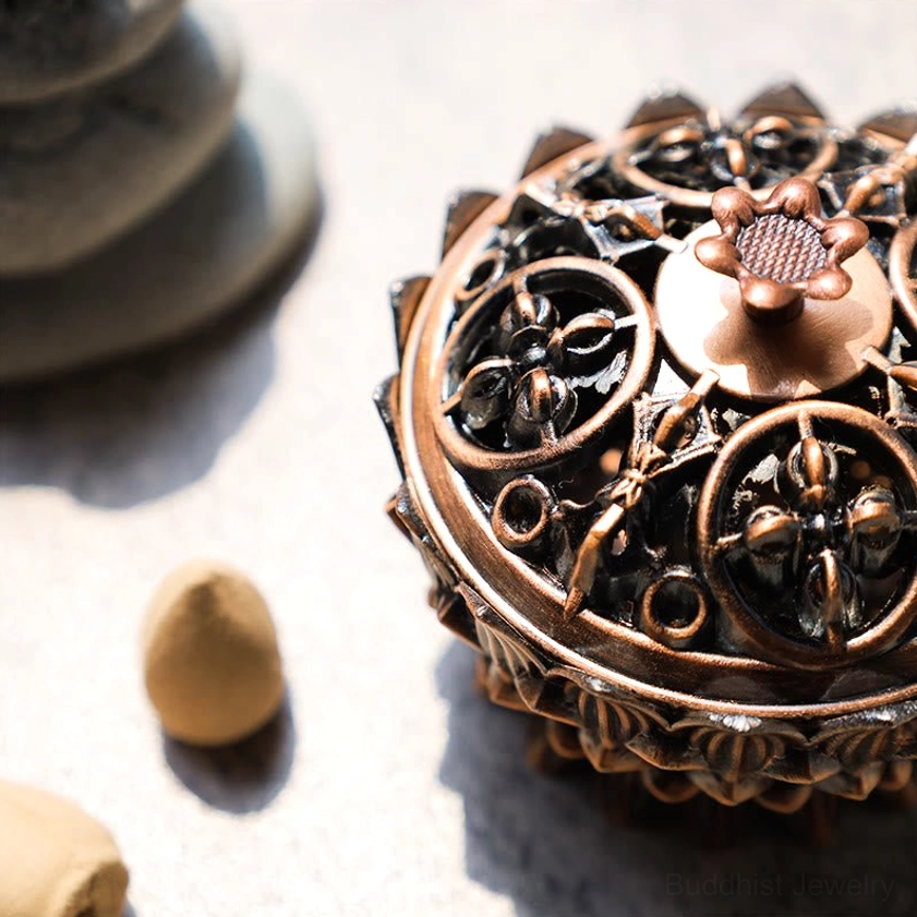 Close-up lotus incense burner showing intricate carved hollow patterns and lotus petal rim on base