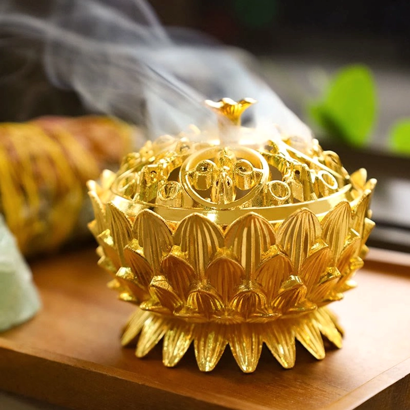 Gold lotus incense burner three-quarter front view with bright polished finish and elaborate hollow carved lid on wooden tray