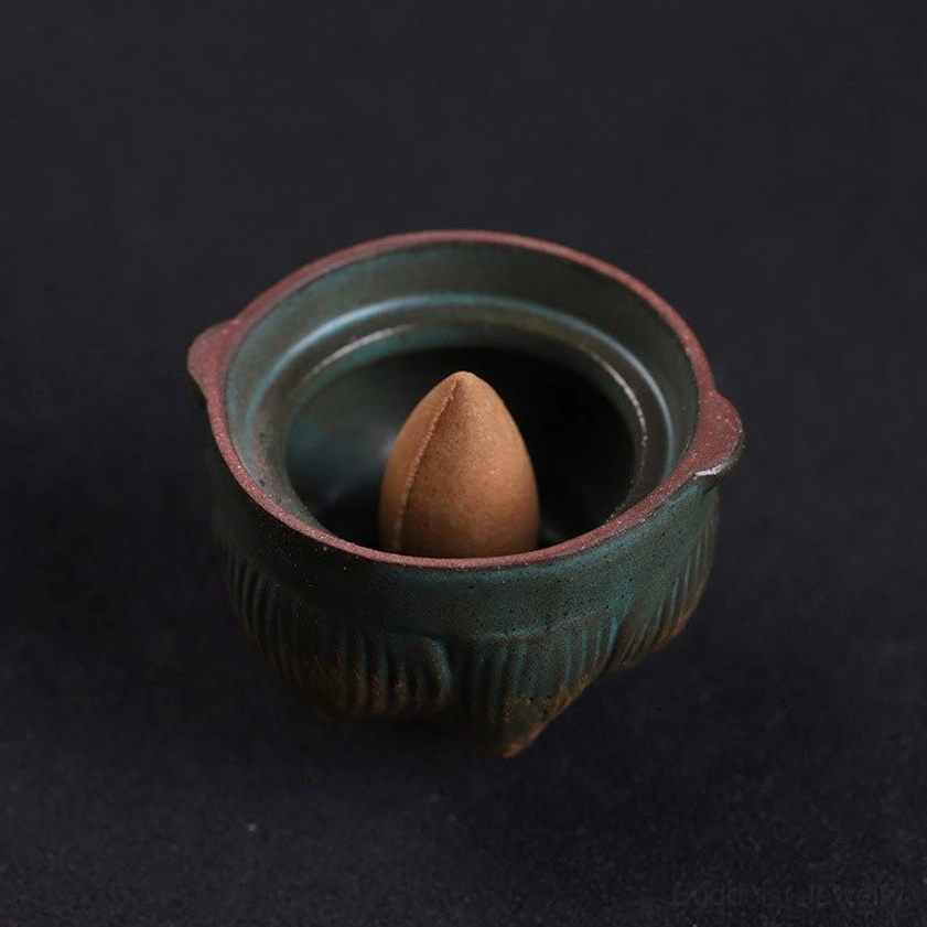 Open lotus incense burner vessel from top-down view, dark green ceramic interior with backflow incense cone and brown rim detail