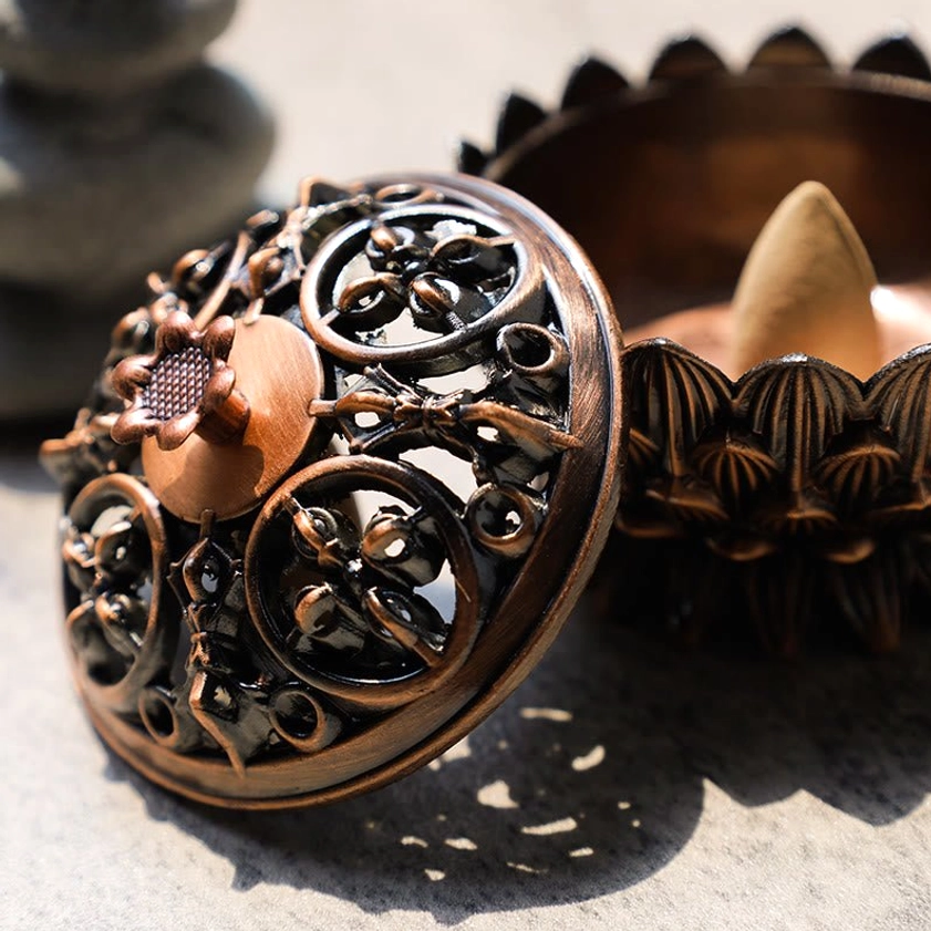 Lotus incense burner with detachable lid overhead flat lay showing backflow incense cone inside and openwork floral design