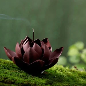 Handcrafted lotus purple clay incense burner with dark maroon layered petals and burning incense stick, side high-angle view