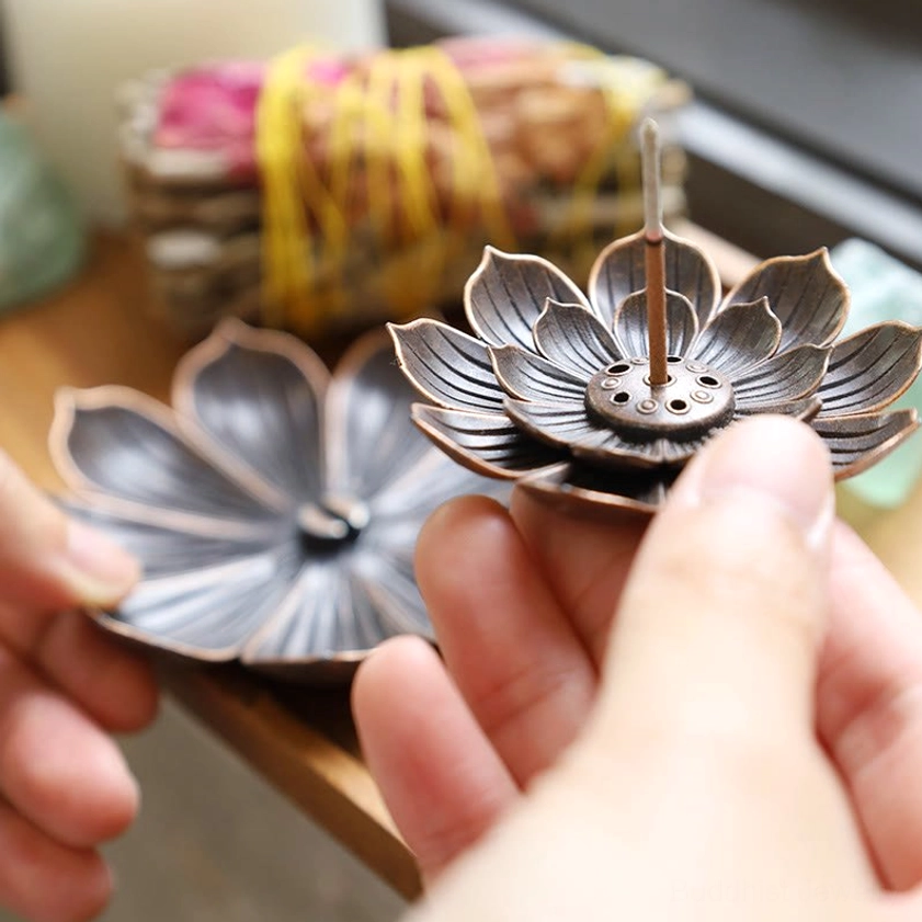 Two handcrafted lotus incense burners close-up view in hand, dark bronze finish with layered petal design