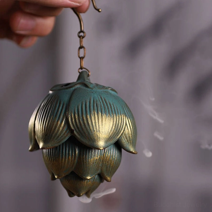 Close-up of lotus incense holder held in hand, showing vintage metal finish and rising aromatic smoke, indoor eye-level perspective