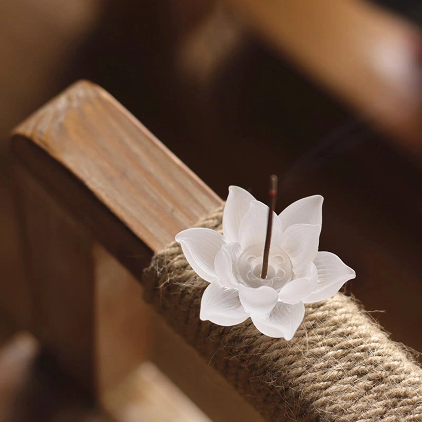 Side view white lotus crystal incense burner burning incense stick wooden furniture warm setting