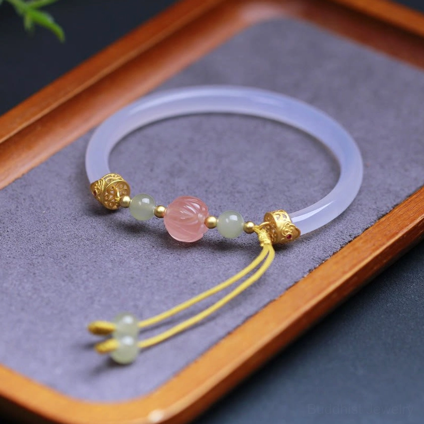 Close-up detail of carved lotus centerpiece and Hetian jade beads on white agate Buddhist bracelet