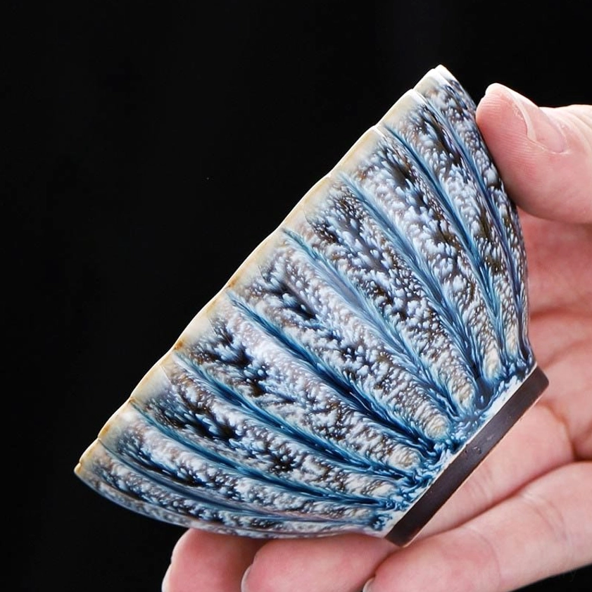Side profile of handmade lotus jian zhan tea cup showing vertical fluted petal texture