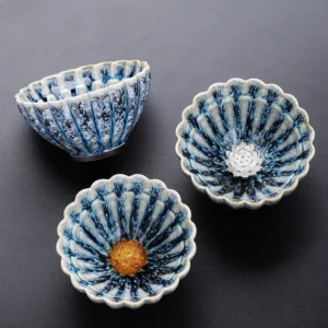 Handmade lotus jian zhan ceramic tea cup with blue mottled glaze and gold floral inlay top view