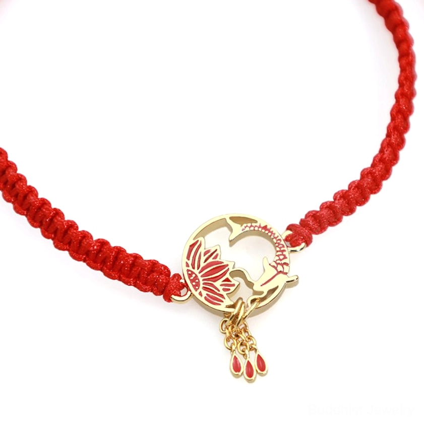 Close-up of lotus koi red string bracelet showing detailed hollow charm, red drop tassels, and braided red rope texture