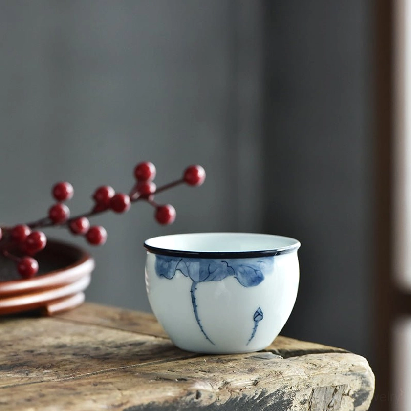 Single lotus leaf and bud motif tea cup, blue-and-white ceramic with dark rim detail