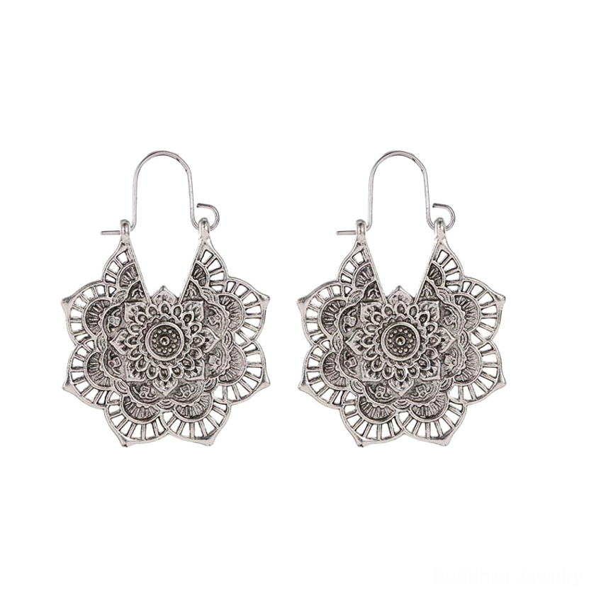 Silver lotus mandala drop earrings with hollow carved pattern and delicate hand-engraved design, flat lay on white