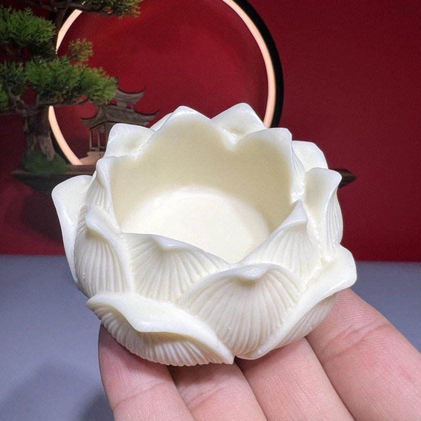 Overhead close-up of hollow lotus-shaped bowl with detailed petal carvings - ivory fruit
