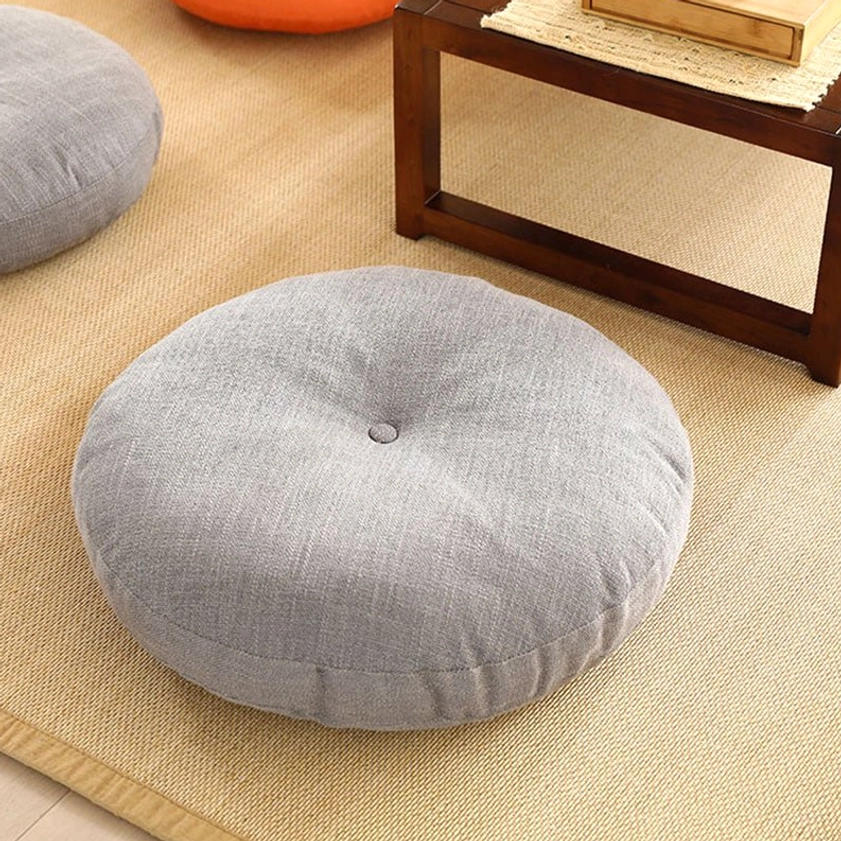 Light gray linen tufted lotus meditation seat cushion high-angle view on rug-covered floor