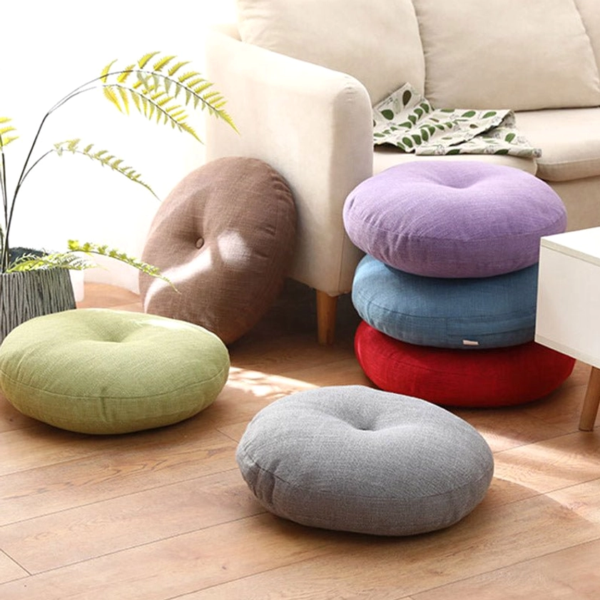 Multiple lotus floor meditation cushions in assorted colors displayed in cozy living room setting