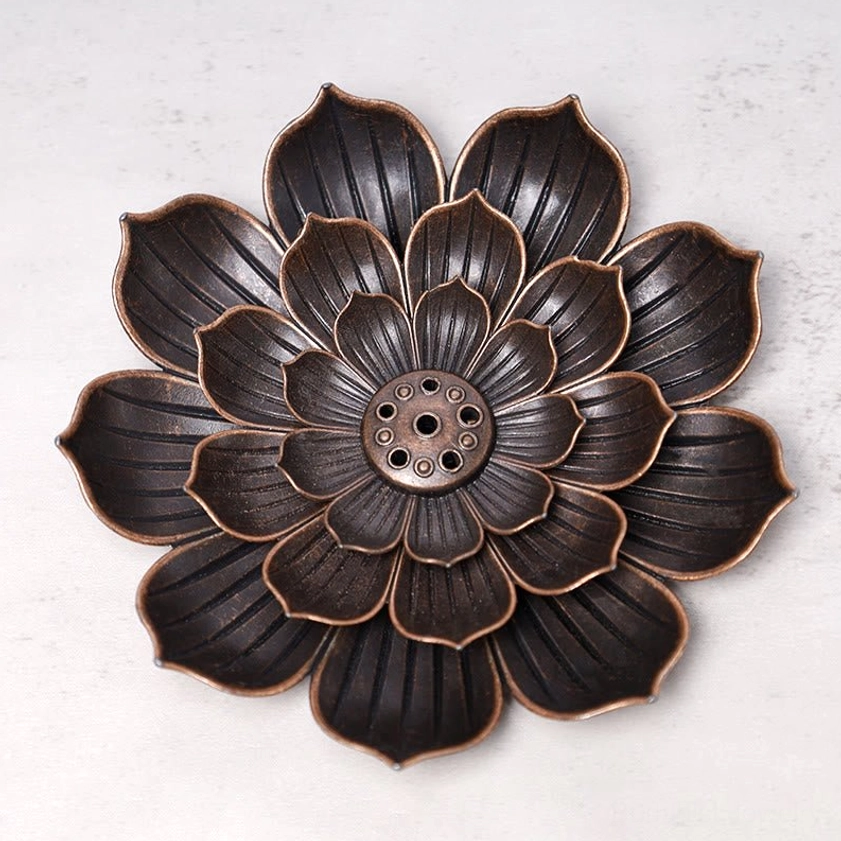 Intricate lotus-petal metal incense holder close-up showing layered bronze texture
