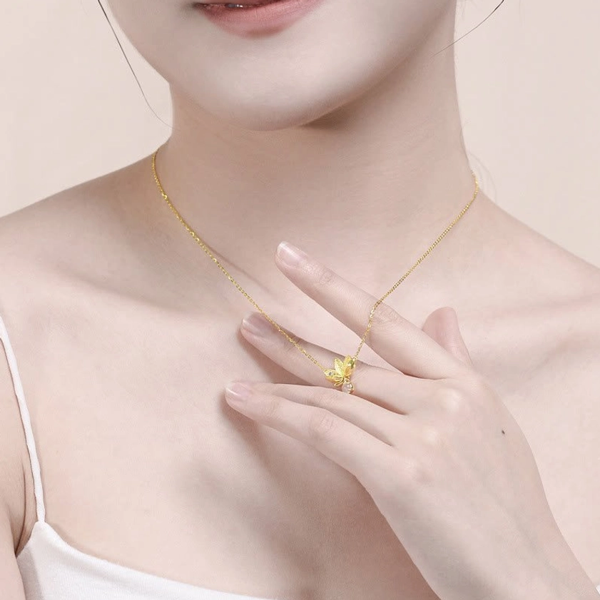 Woman wearing dainty lotus pendant necklace daily styling three-quarter view hand touching pendant
