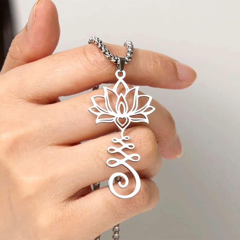 Hand-held silver lotus spiritual necklace pendant showing wearable perspective and intricate hollow carved pattern
