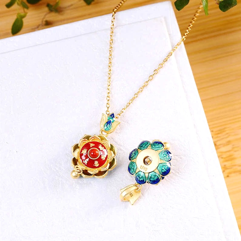 Sterling silver lotus prayer wheel pendant with detachable spare flower charm and fine gold-plated chain set on white display