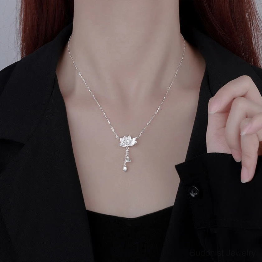 Sterling silver lotus necklace worn on model with black collared blazer, showing everyday styling and elegance